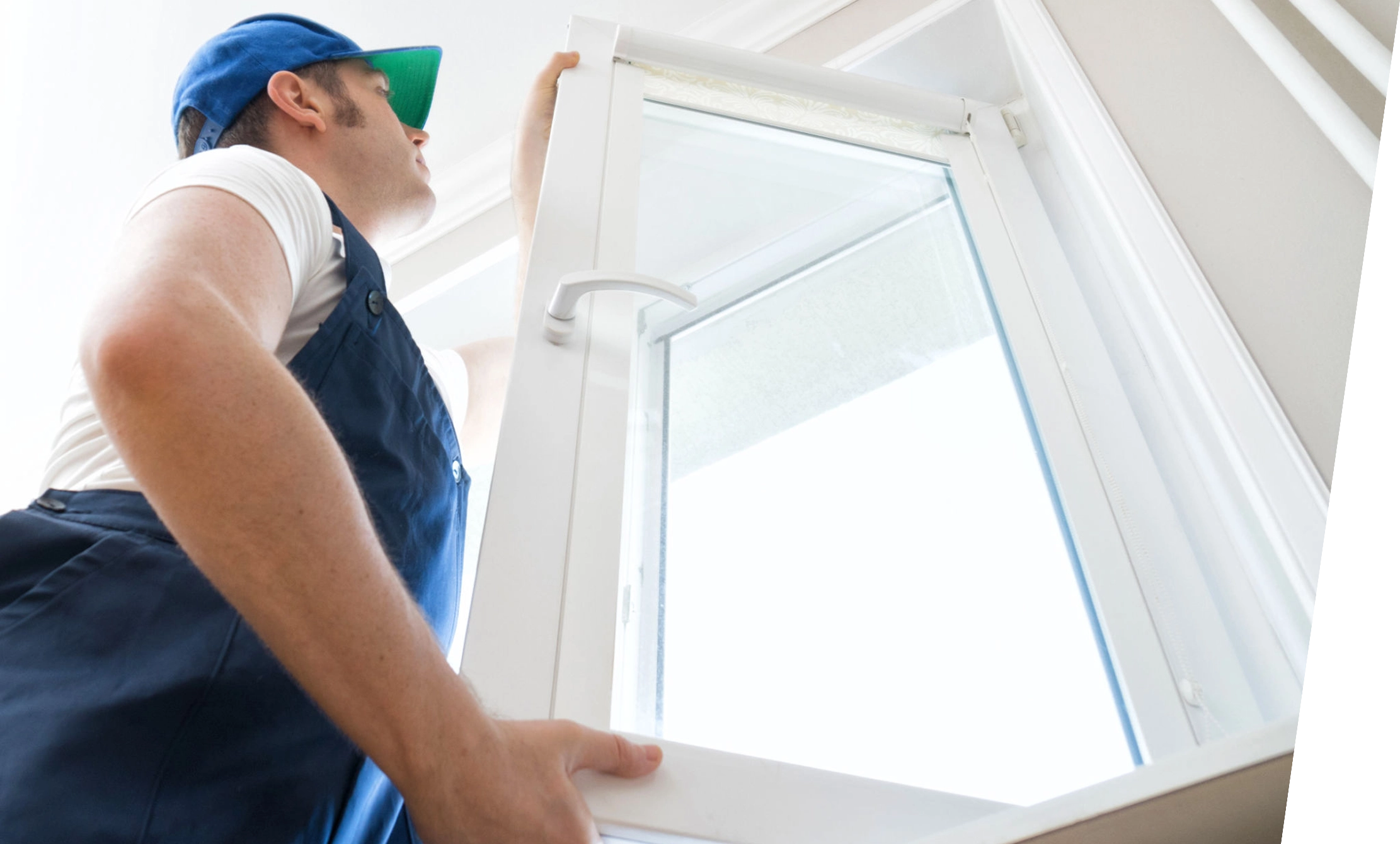 Worker installing a new window indoors.